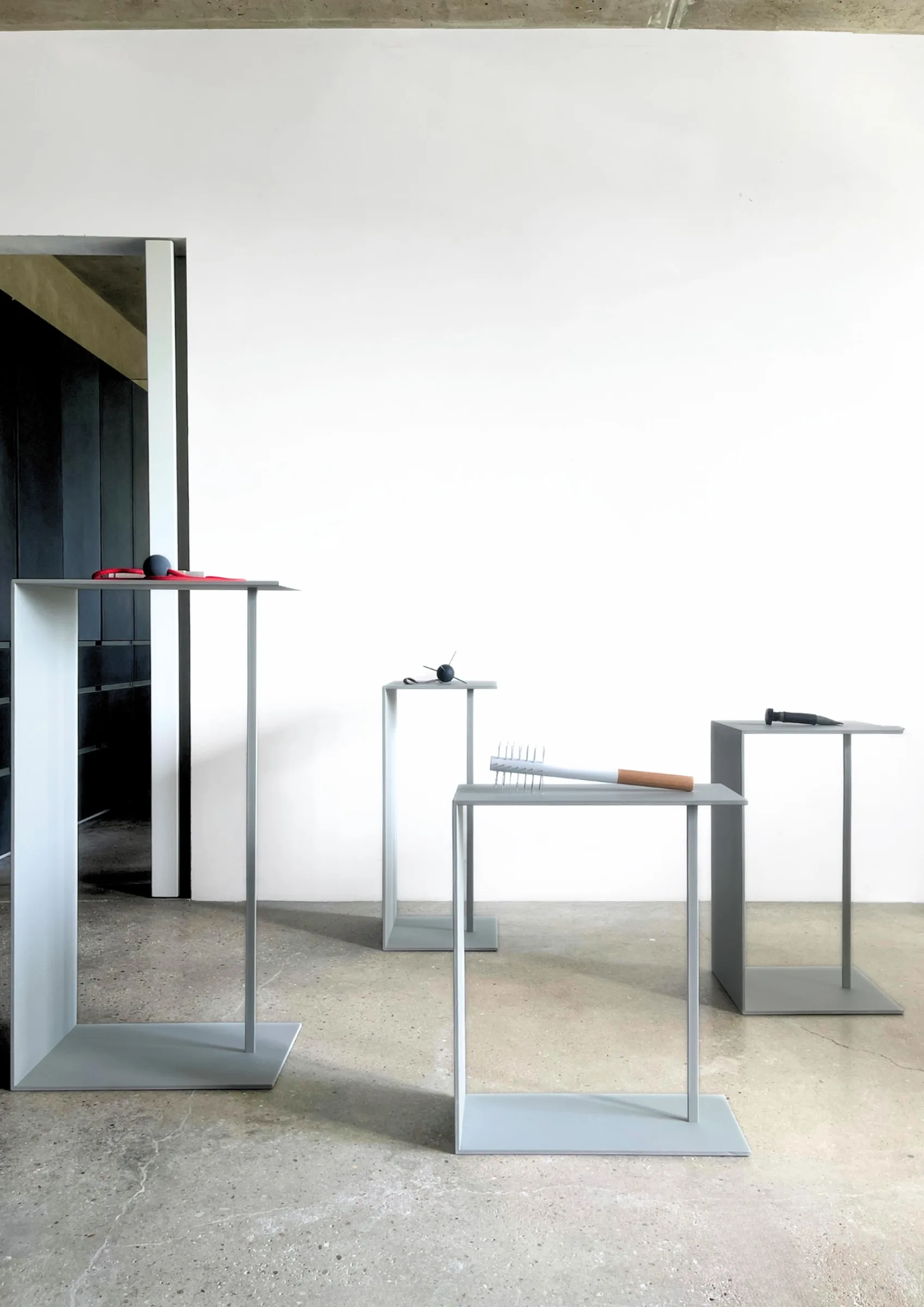Defence Offence installation view by Barbara K. Prokop showing conceptual sculptures displayed on grey metal pedestals