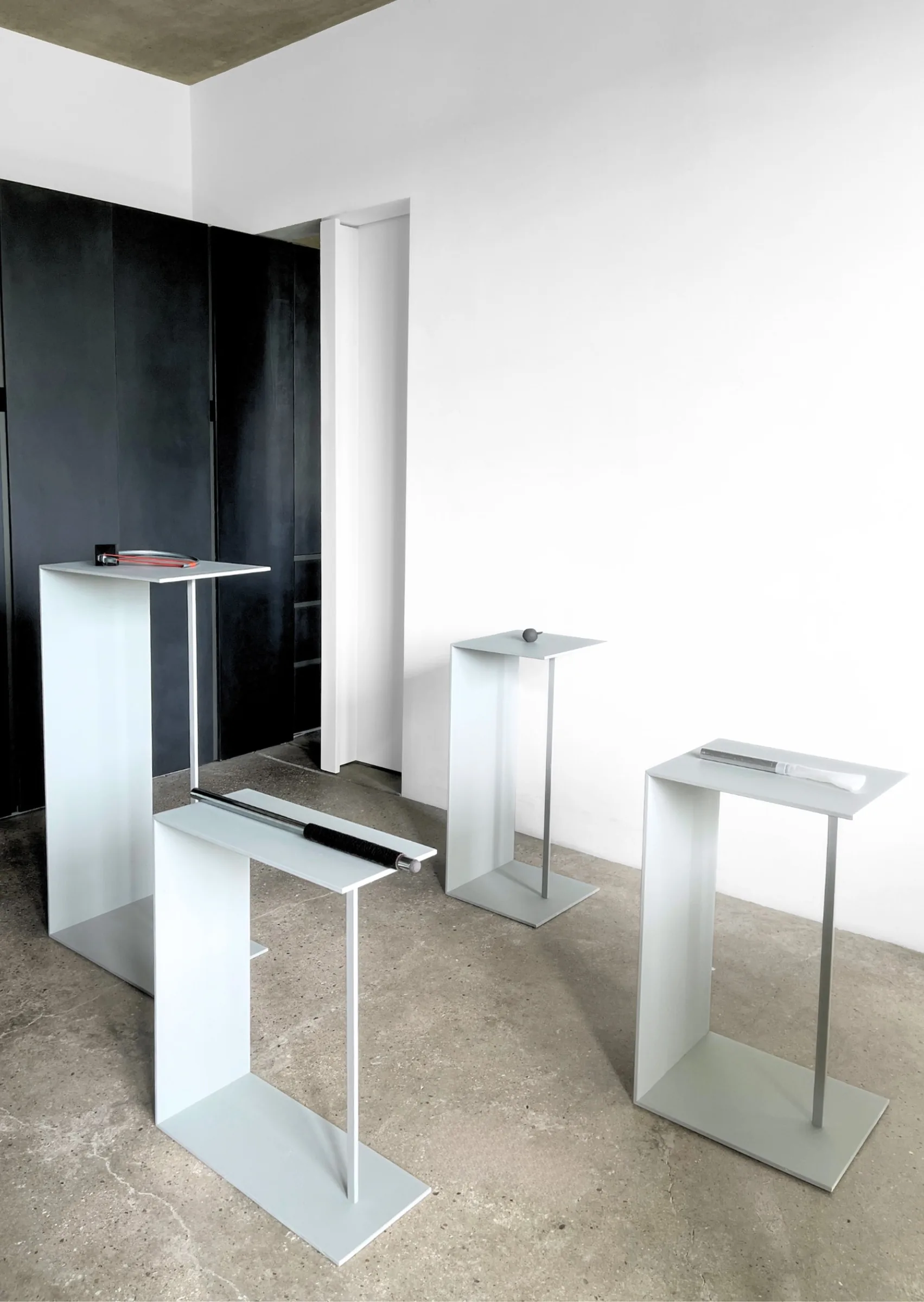 Defence Offence installation view by Barbara K. Prokop showing sculptural objects arranged across grey metal pedestals